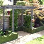 Timber pergola set within a topairy hedge